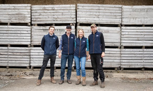 Four people standing in a farmyard